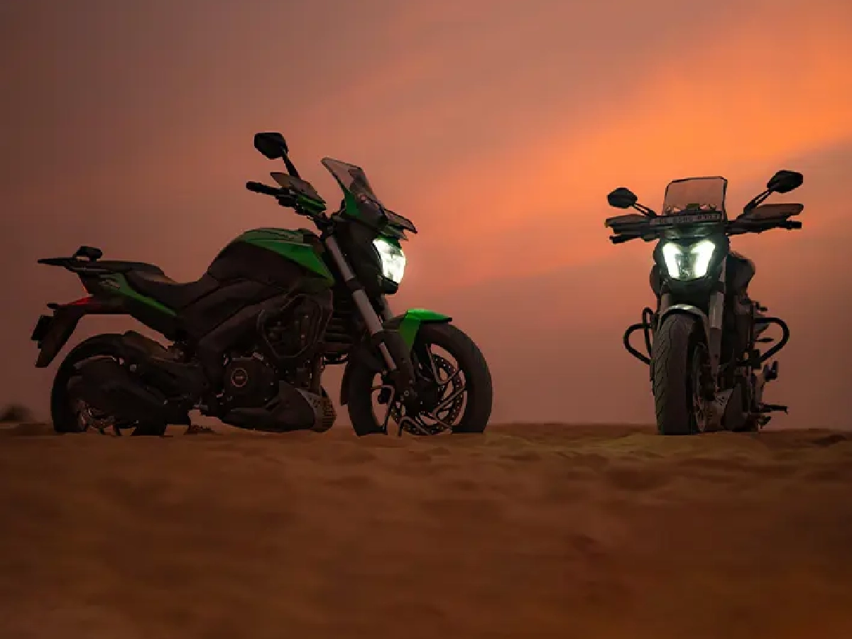 Bajaj Dominar 400 motorcycles parked on sand dunes during sunset