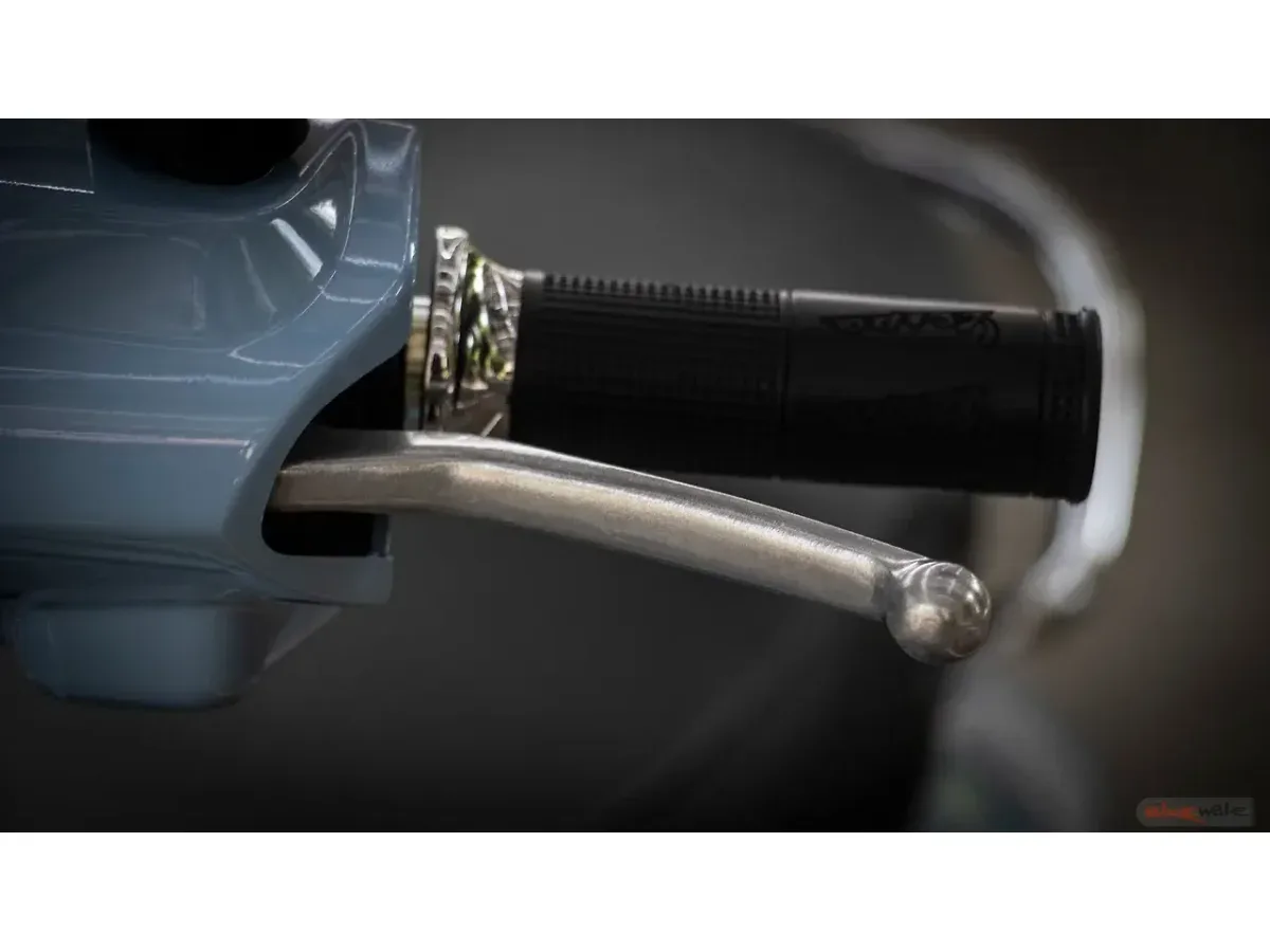 Close-up of the Vespa SXL 150 handbrake lever and handlebar
