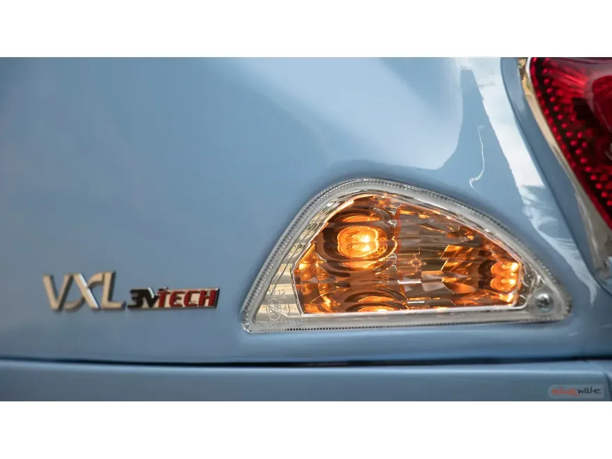 Close-up of the Vespa SXL 150 turn signal and body badge